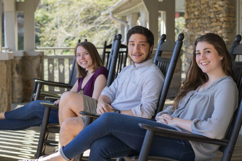 Montreat Young Adult Experience posed in rocking chairs on porch of Left Bank.