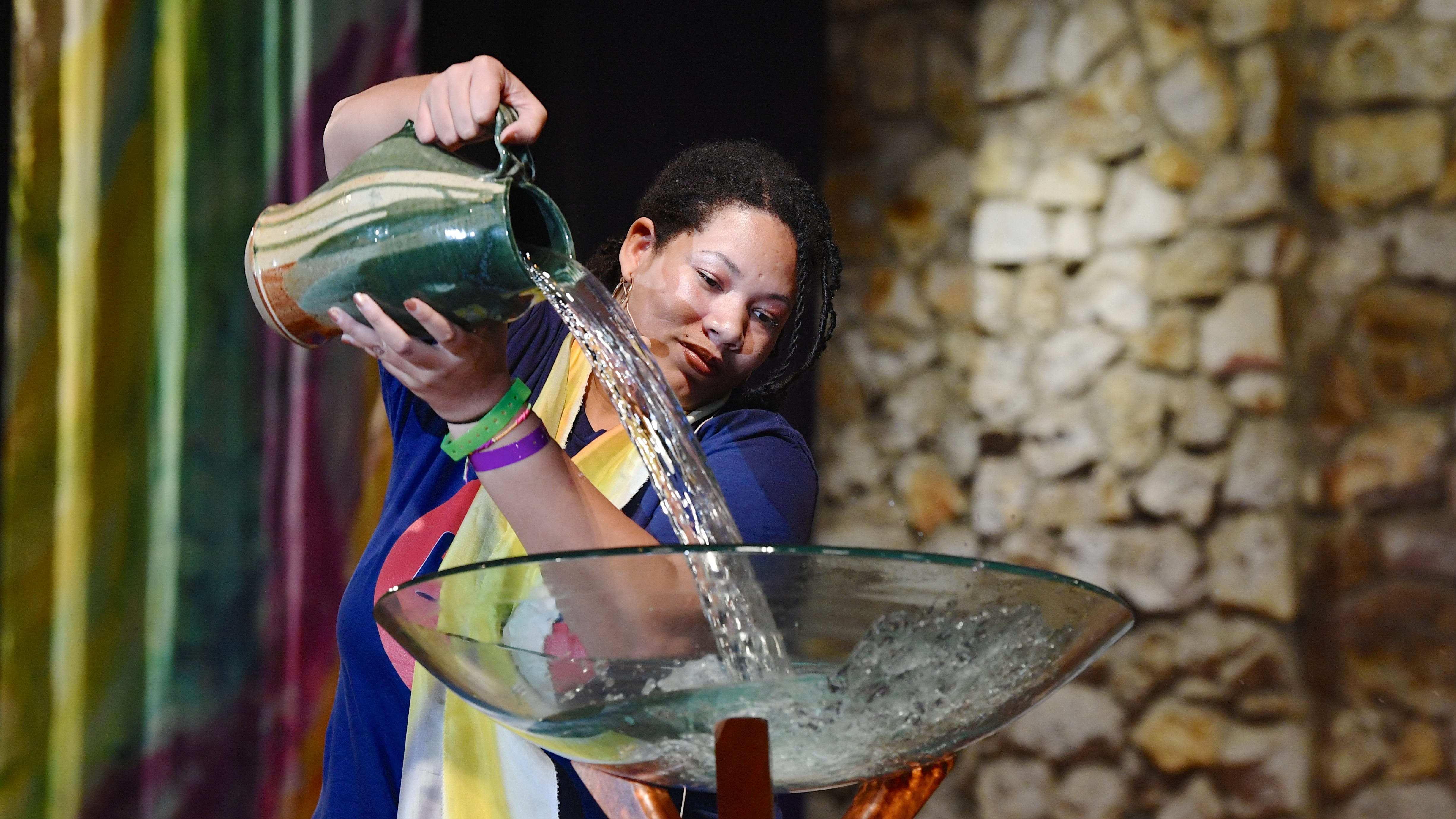 Woman pouring water into basin during worship.